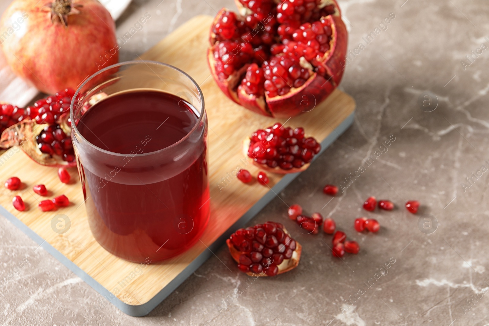 Photo of Composition with glass of fresh pomegranate juice on table. Space for text