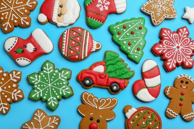 Different tasty Christmas cookies on light blue background, flat lay