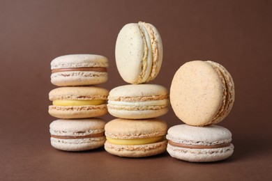 Pile of delicious colorful macarons on brown background
