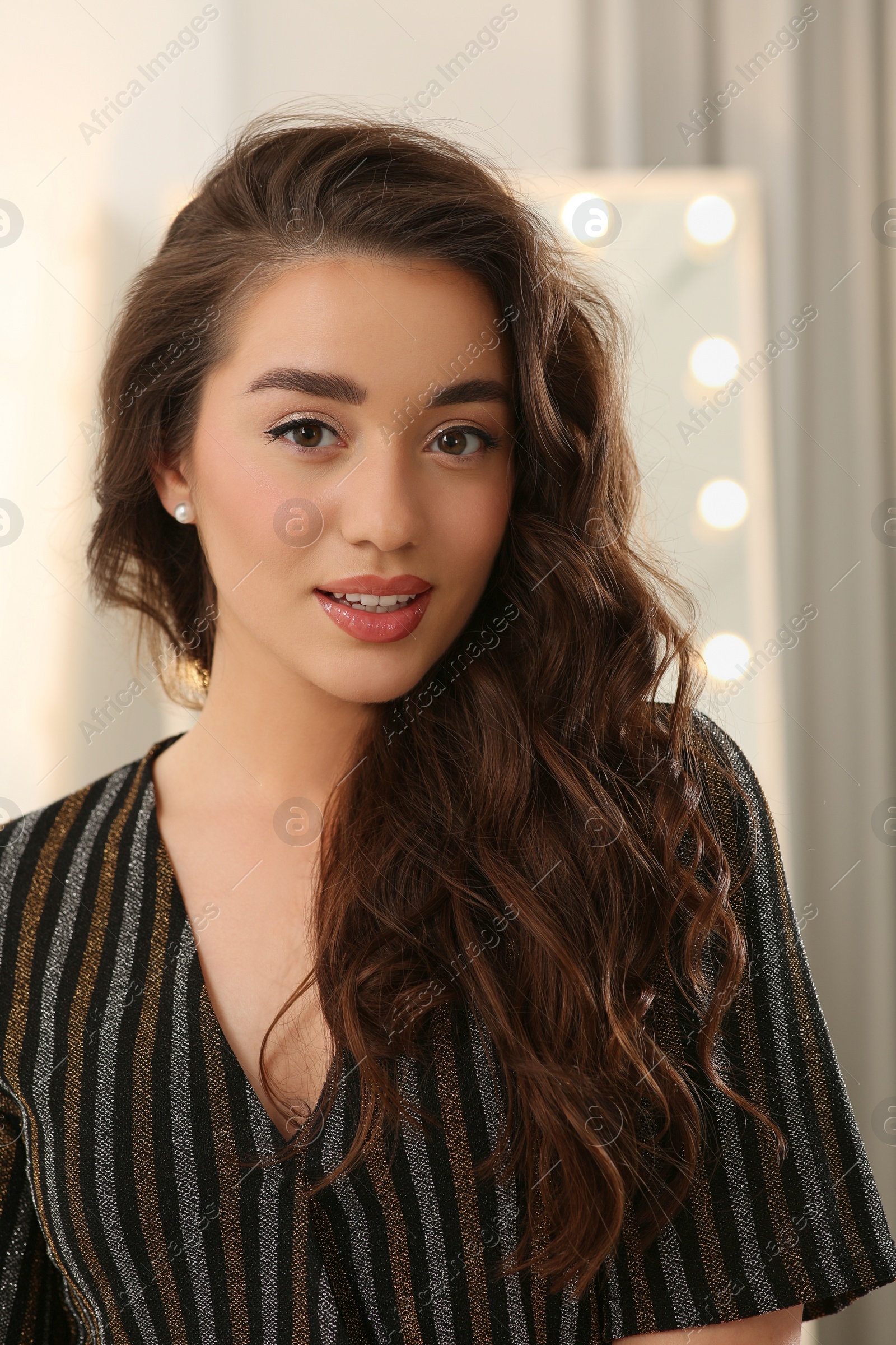 Photo of Portrait of beautiful young woman with wavy brown hair indoors