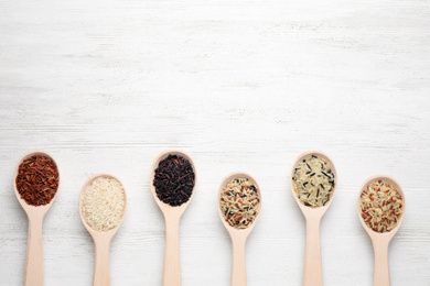 Photo of Flat lay composition with brown and polished rice on white wooden table. Space for text