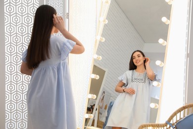 Woman trying on stylish dress in showroom