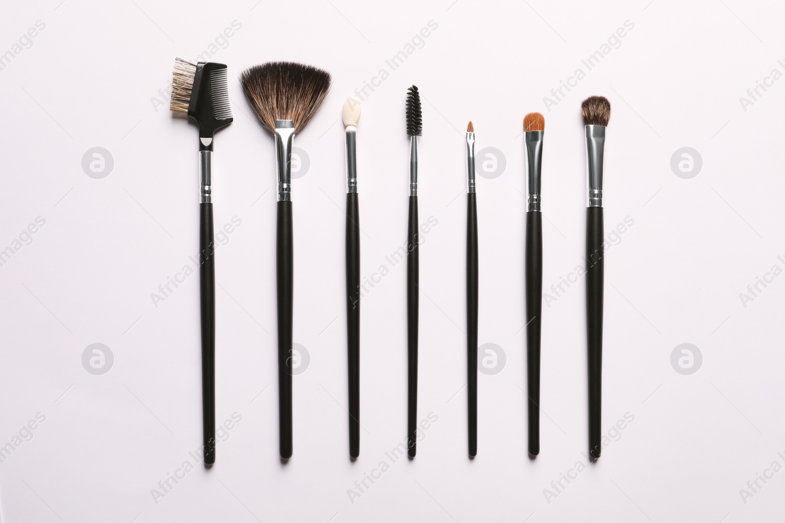 Photo of Different makeup brushes on white background, flat lay