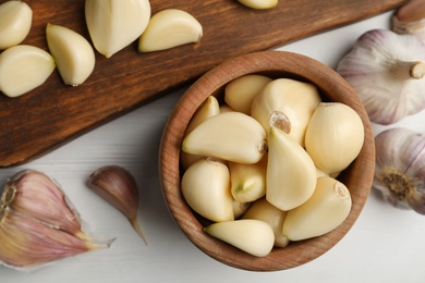 Photo of Fresh organic garlic on white wooden table, flat lay