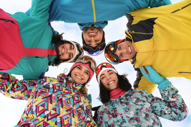 Photo of Group of friends joined in circle outdoors, bottom view