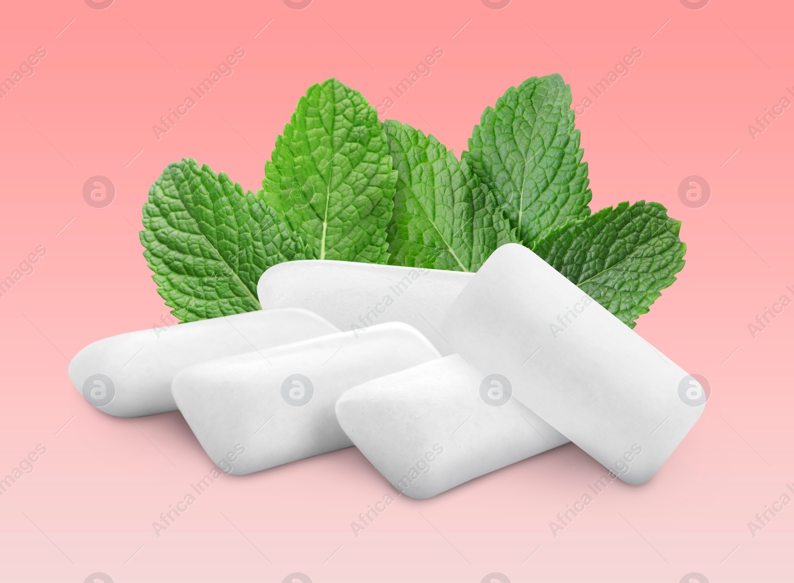 Image of Menthol chewing gum pillows and mint leaves on pink gradient background