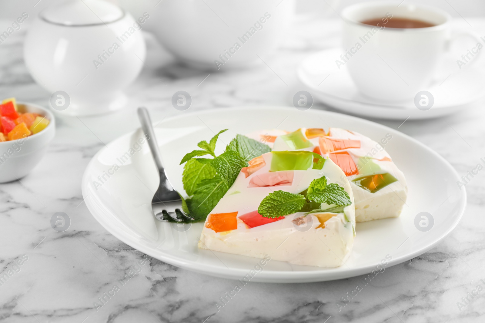 Photo of Delicious broken glass jelly dessert on white marble table