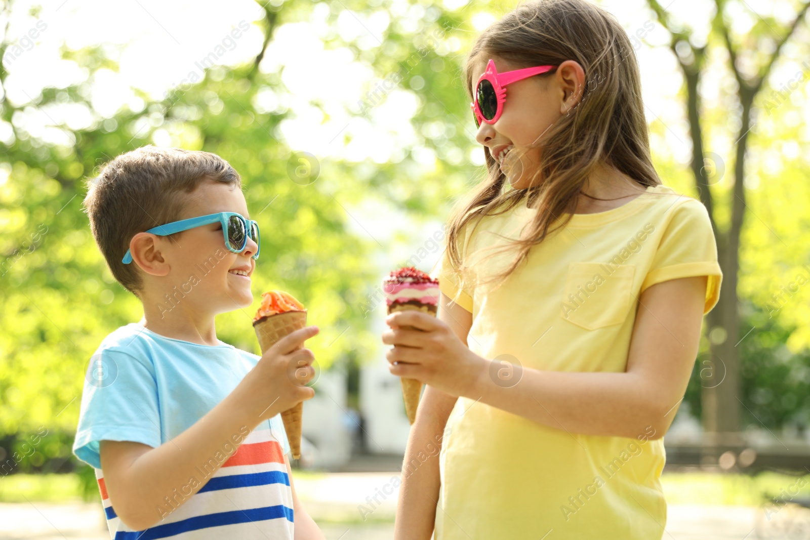 Photo of Cute little children with delicious ice creams outdoors