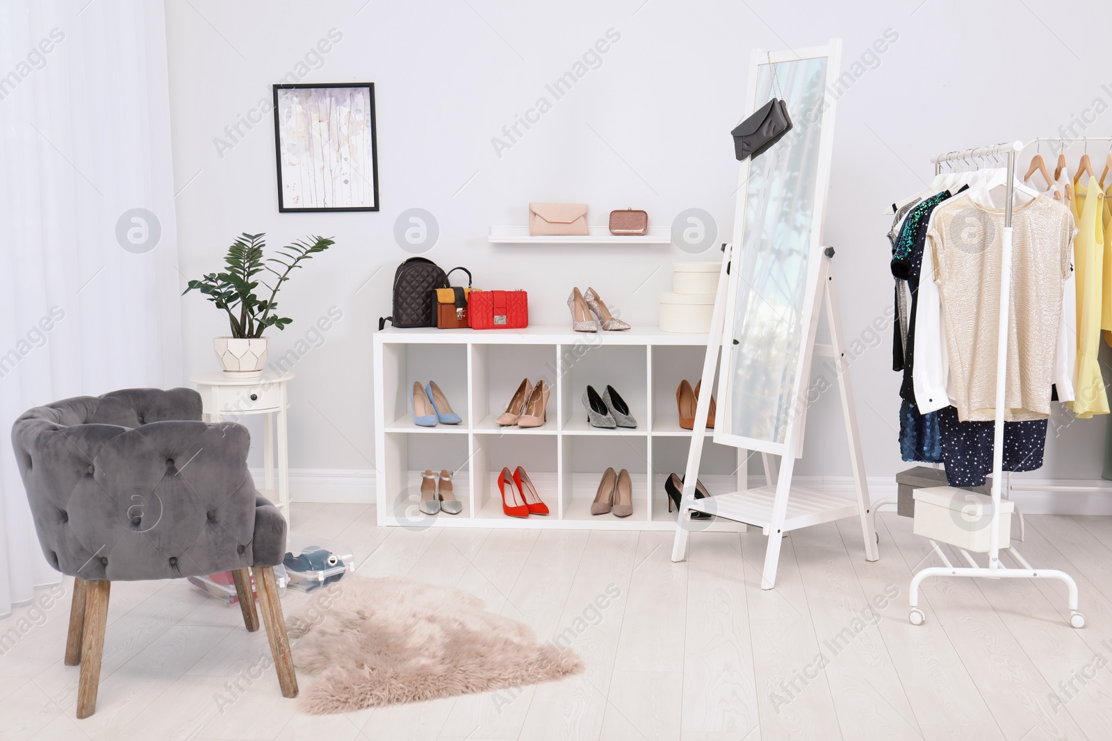 Photo of Light room interior with stylish clothes and shoes