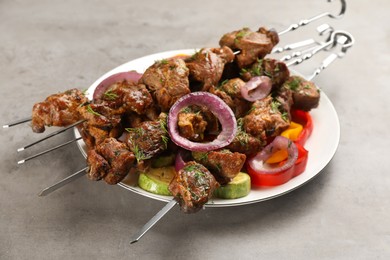 Photo of Metal skewers with delicious meat and vegetables served on light grey table