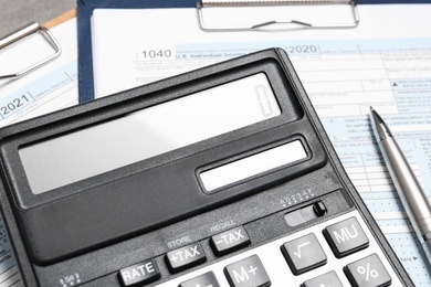 Photo of Calculator, documents and pen on table, closeup. Tax accounting