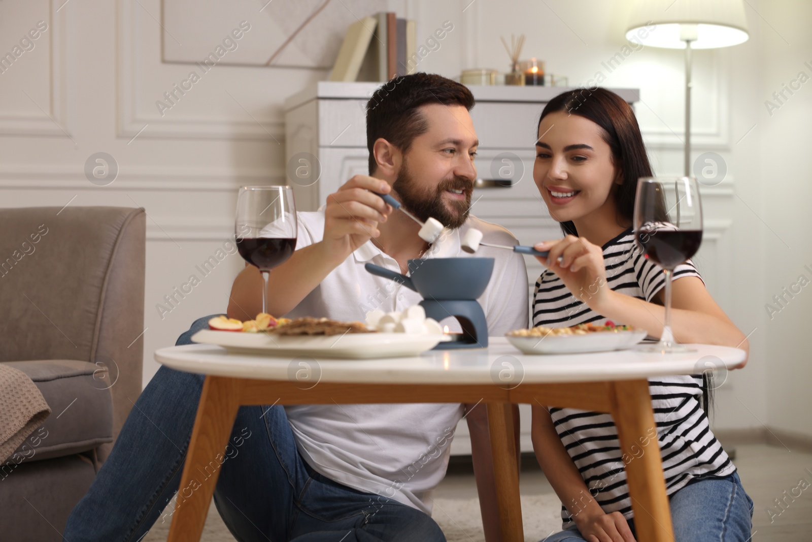 Photo of Affectionate couple enjoying fondue during romantic date at home