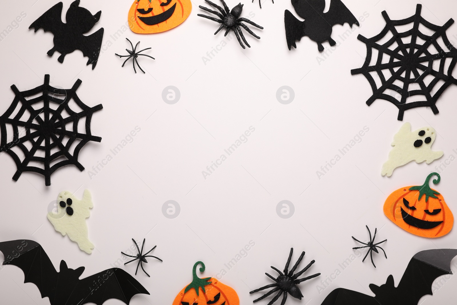 Photo of Frame made of bats, pumpkins, ghosts and spiders on white background, space for text. Halloween celebration