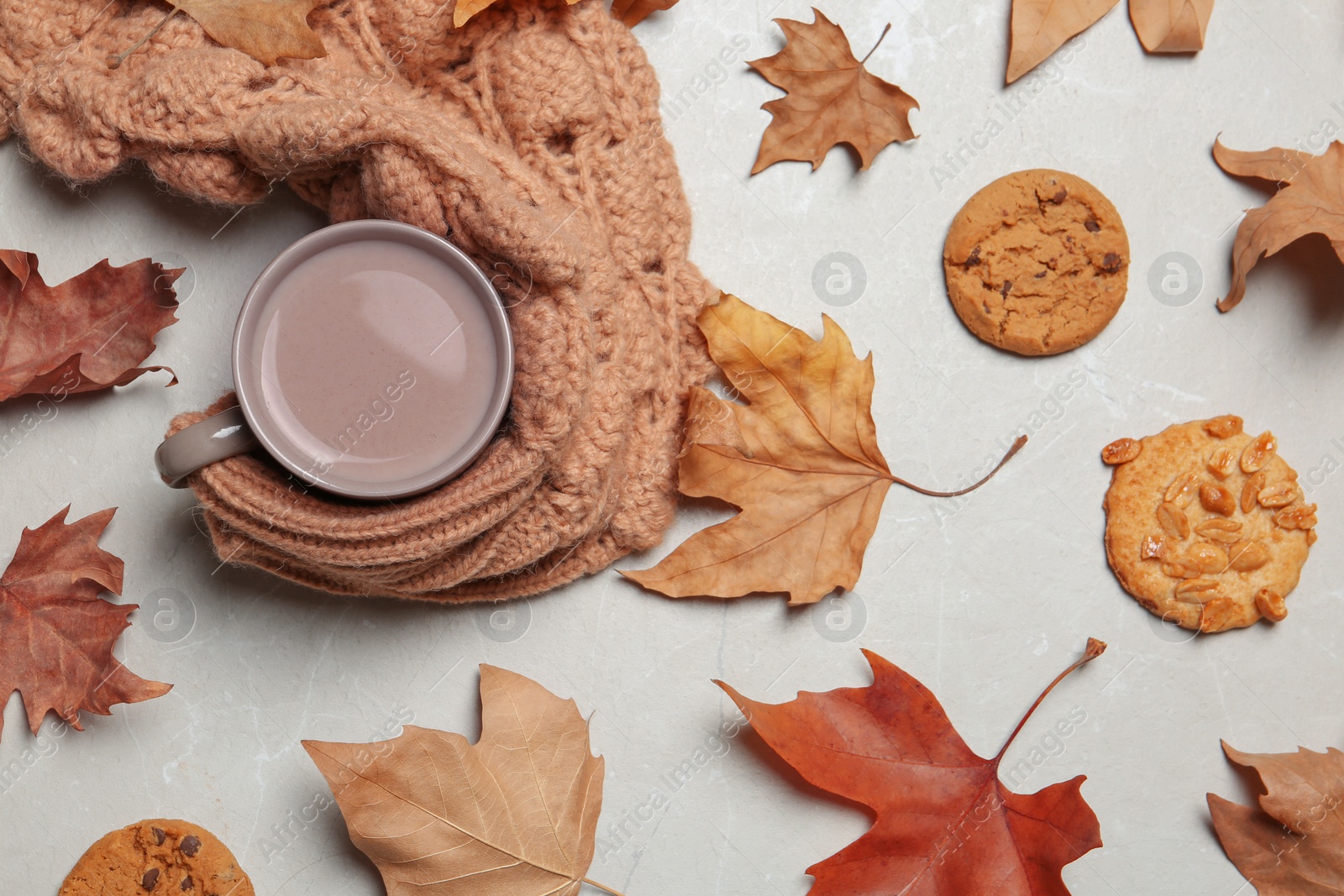Photo of Flat lay composition with hot cozy drink and autumn leaves on light background