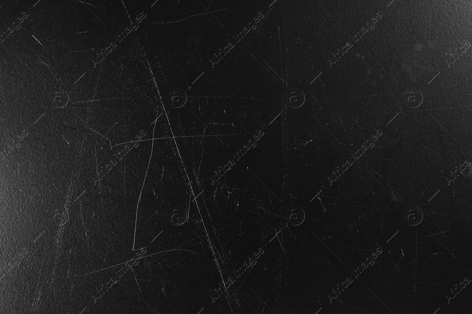 Photo of Old black surface with scratches as background, closeup