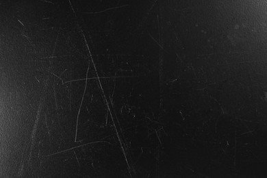 Old black surface with scratches as background, closeup