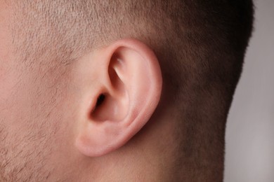 Photo of Man on grey background, closeup of ear