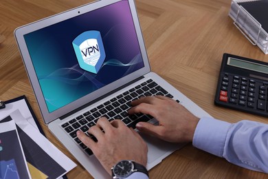 Image of Man using laptop with switched on VPN at table, closeup