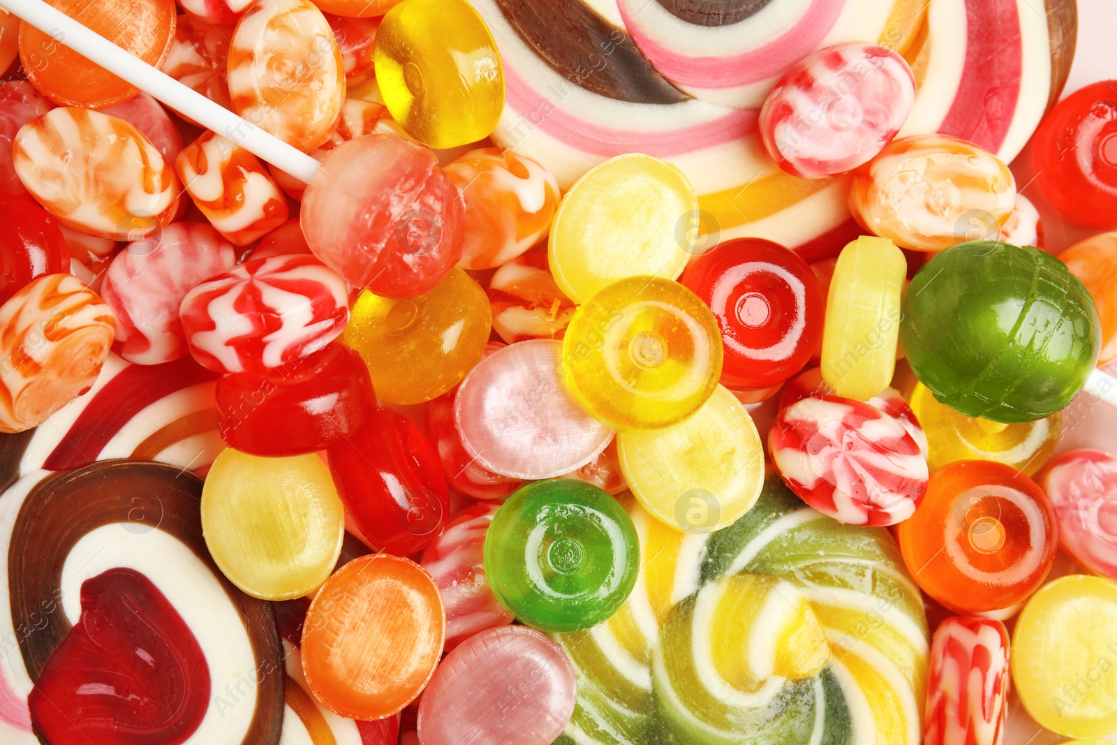 Photo of Different delicious colorful candies as background, top view