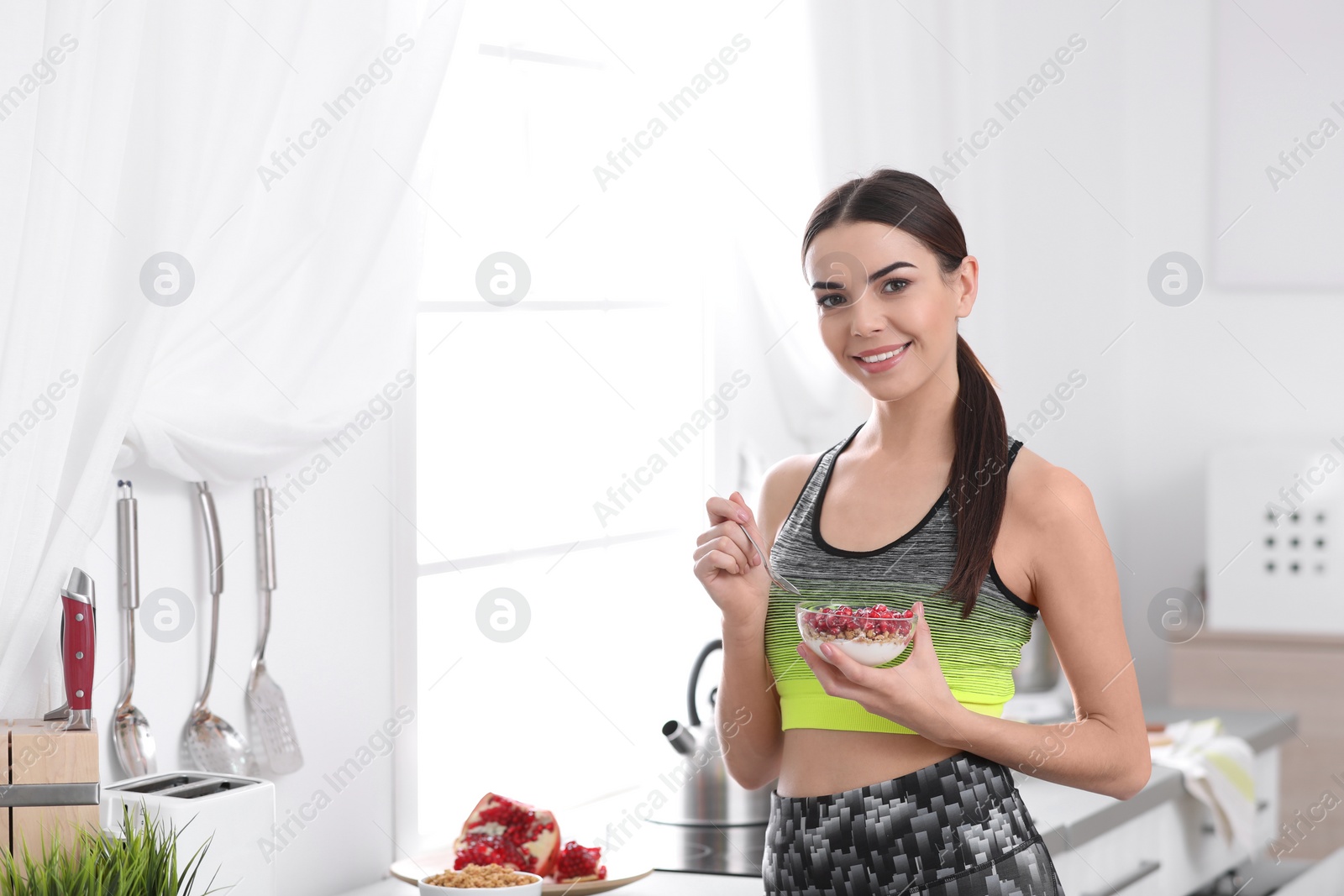 Photo of Young woman in fitness clothes having healthy breakfast at home. Space for text