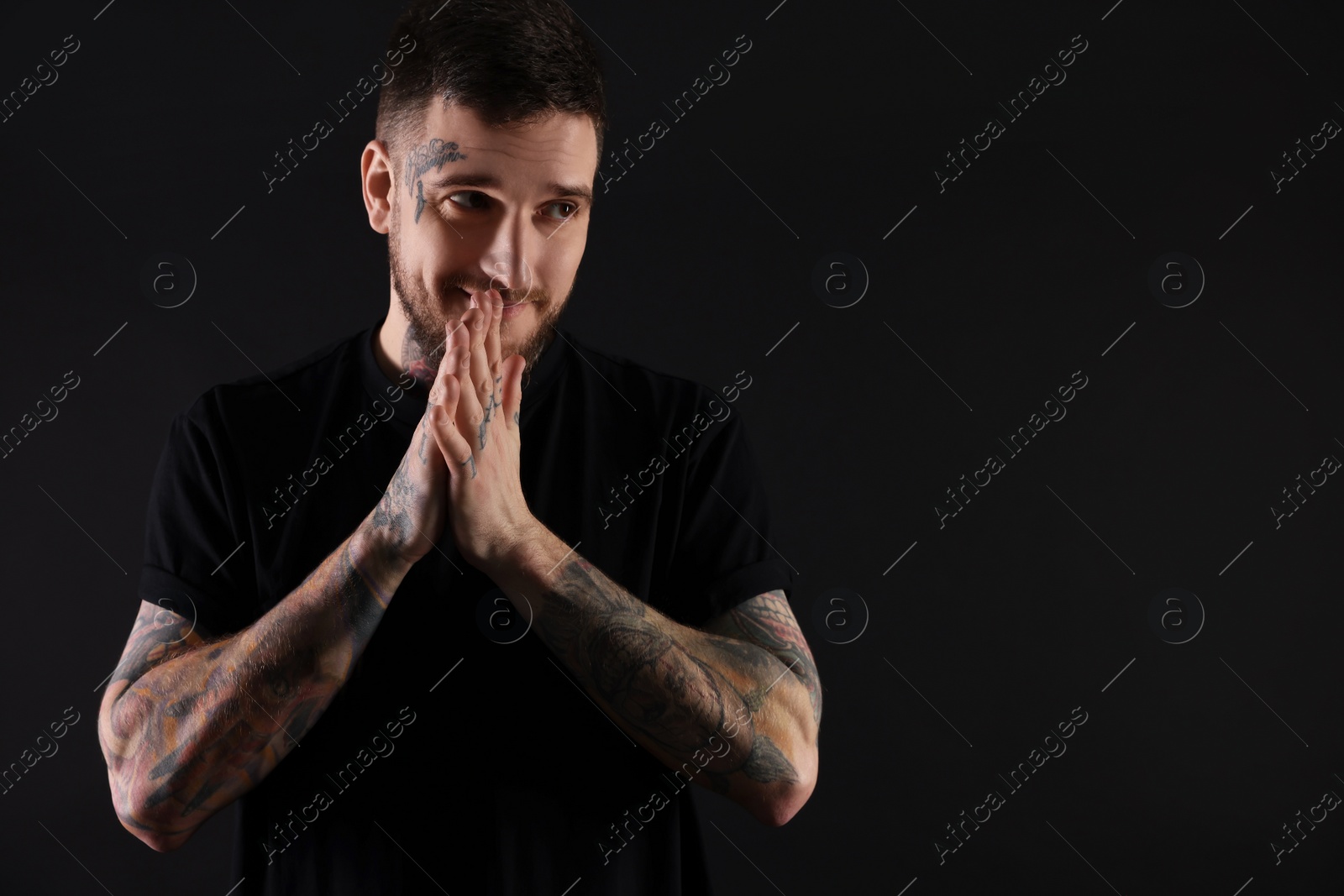 Photo of Handsome hipster man posing on black background. Space for text