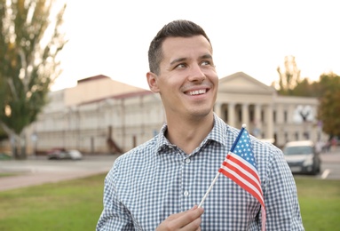 Photo of Man with American flag on city street