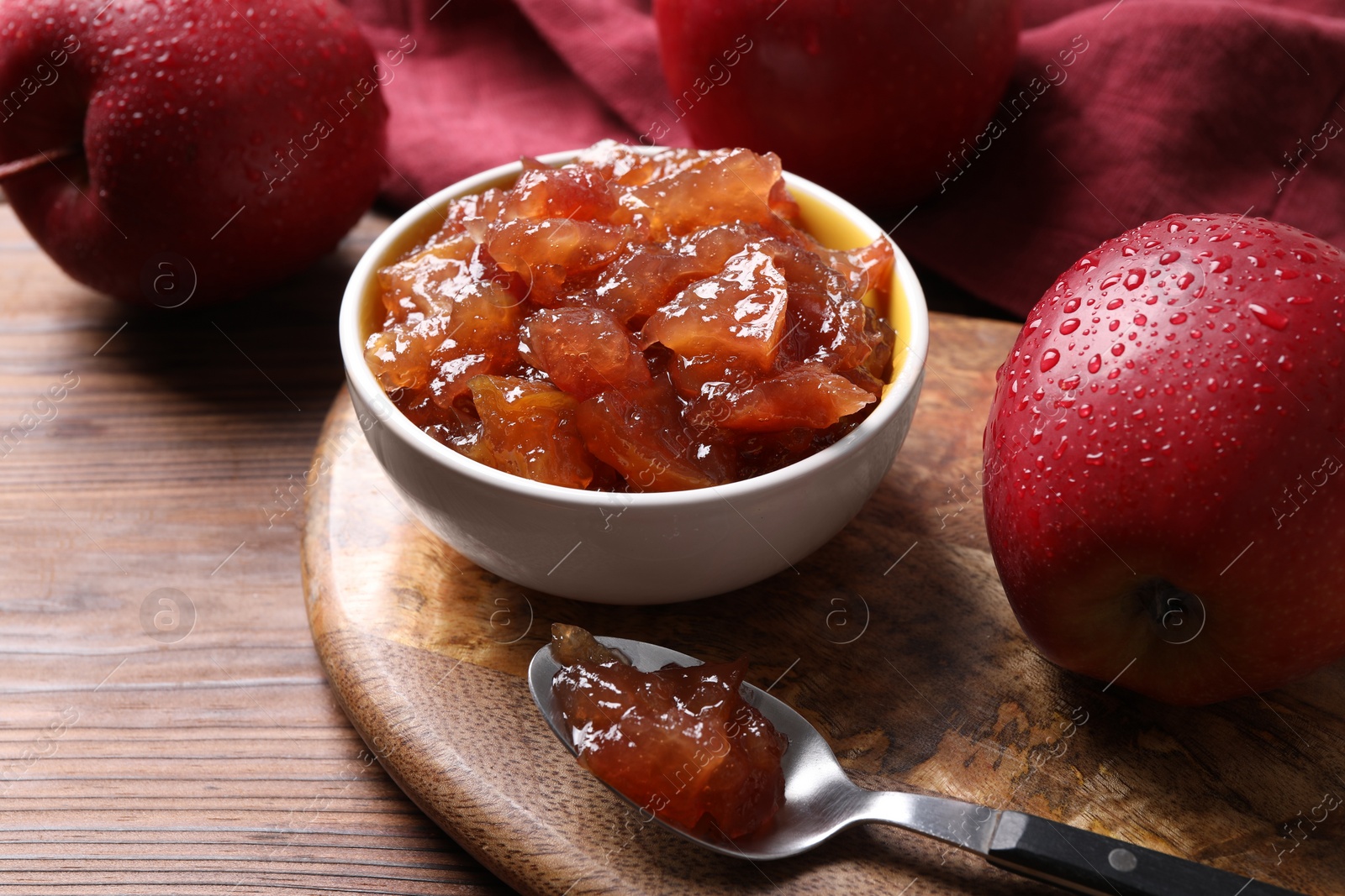 Photo of Delicious apple jam and fresh fruits on wooden table, closeup