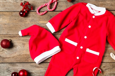 Photo of Flat lay composition with Christmas baby clothes on wooden background