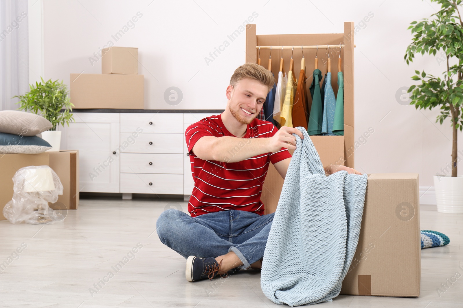 Photo of Young man near wardrobe box at home