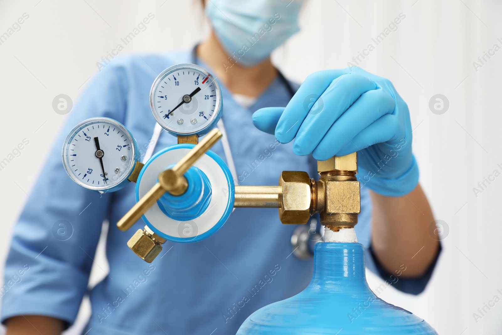 Photo of Medical worker checking oxygen tank in hospital room, closeup