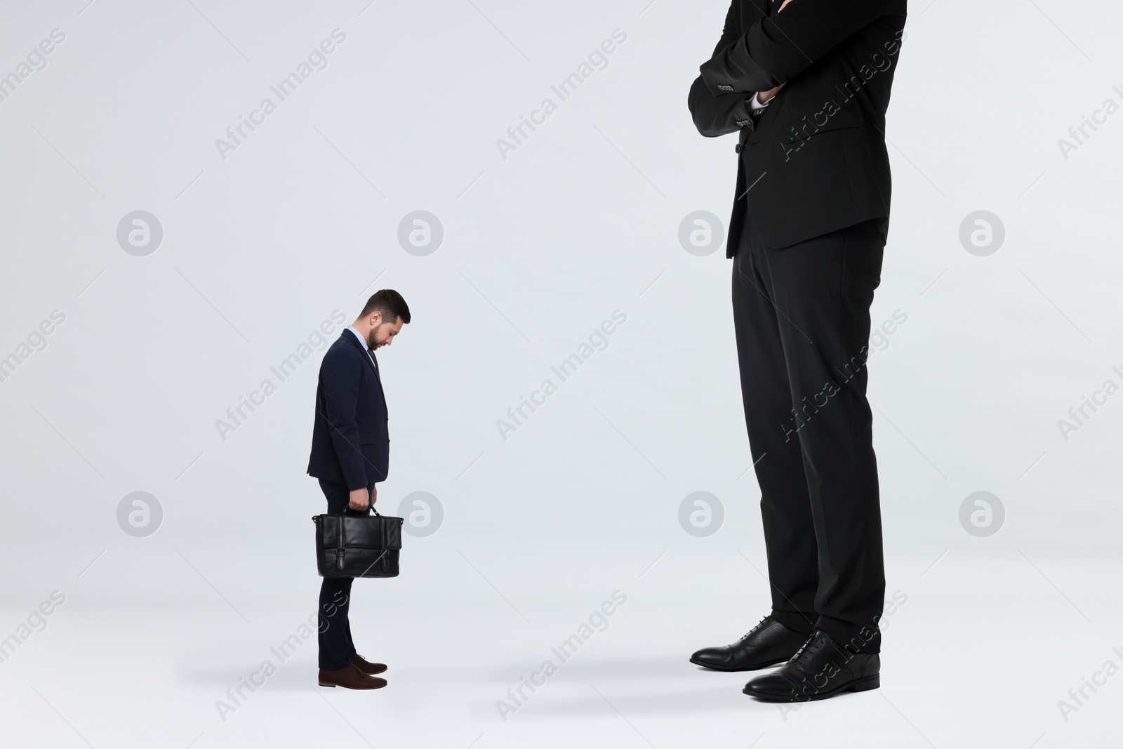 Image of Giant boss and sad small man on light background