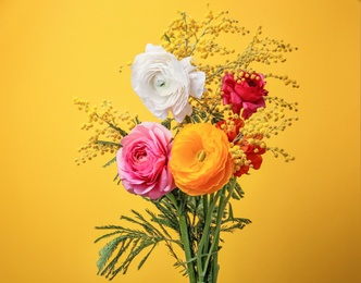 Photo of Beautiful ranunculus and mimosa flowers on color background