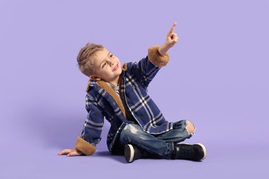 Fashion concept. Stylish boy posing on violet background