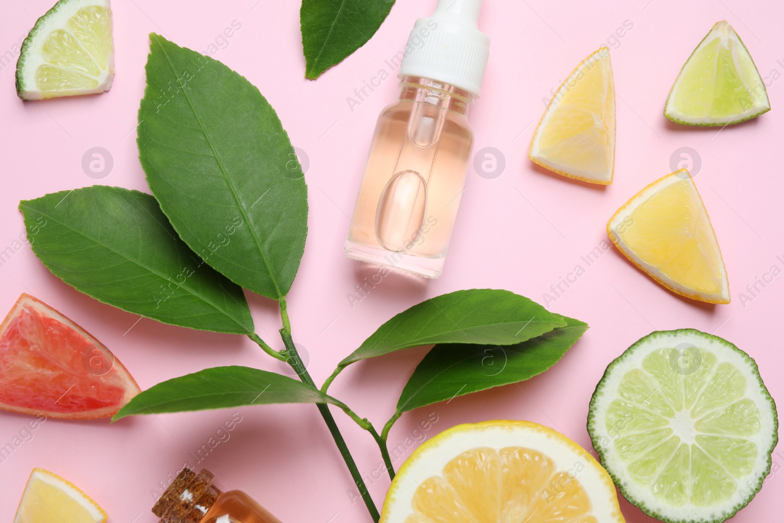 Photo of Flat lay composition with bottles of citrus essential oil on pink background