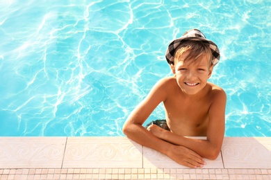 Photo of Happy cute boy with hat in swimming pool