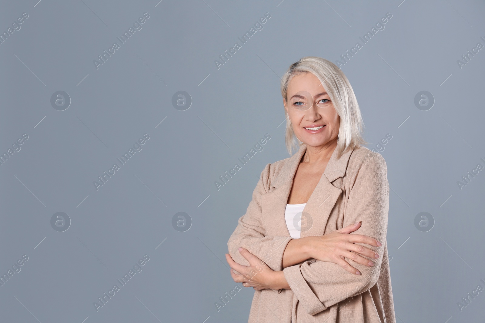 Photo of Portrait of beautiful mature woman on grey background. Space for text