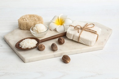 Photo of Composition with Shea butter and nuts on table