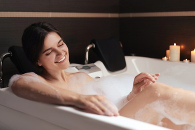 Photo of Happy beautiful woman taking bubble bath. Romantic atmosphere