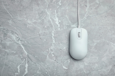 Photo of Wired computer mouse on light grey marble background, top view. Space for text