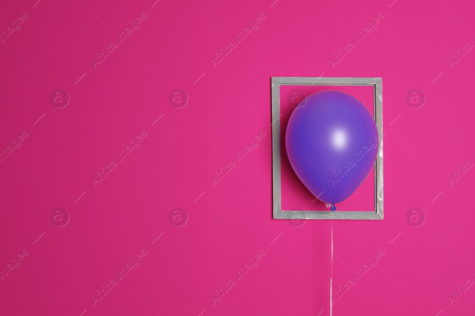 Photo of Purple balloon in frame on color background. Celebration time