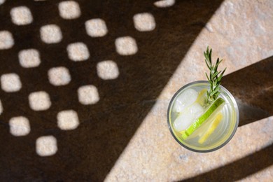 Photo of Summer refreshing lemonade on light brown table, top view. Space for text