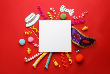 Flat lay composition with carnival items and blank card on red background. Space for text