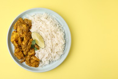 Photo of Delicious chicken curry with rice on yellow background, top view. Space for text