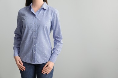 Photo of Woman wearing rumpled light blue t-shirt on white background, closeup. Space for text