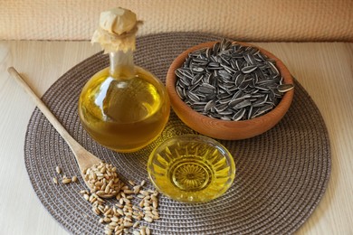 Organic sunflower oil and seeds on white wooden table