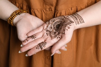 Photo of Woman with beautiful henna tattoo on hand, closeup. Traditional mehndi