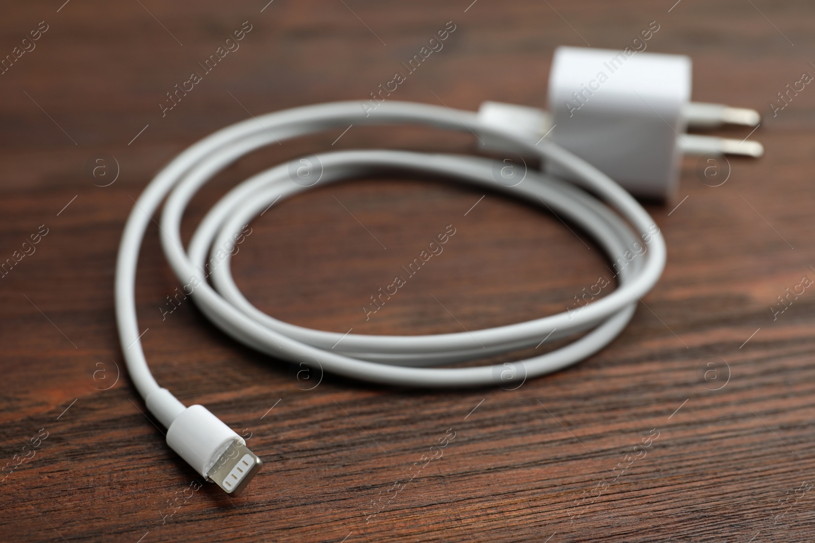 Photo of USB charger on wooden table, closeup. Modern technology