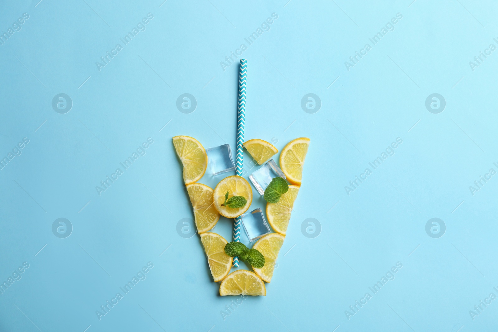 Photo of Creative lemonade layout with lemon slices, mint and ice on light blue background, top view