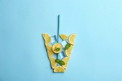 Photo of Creative lemonade layout with lemon slices, mint and ice on light blue background, top view