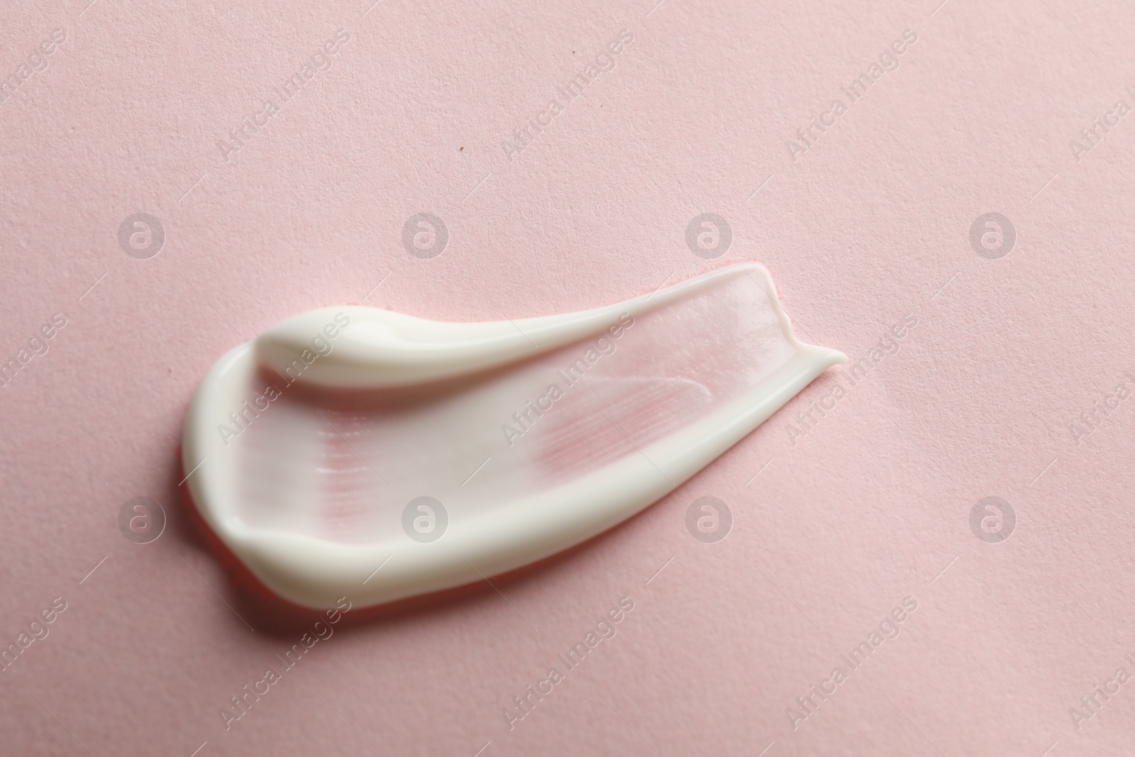 Photo of Sample of face cream on pink background, top view